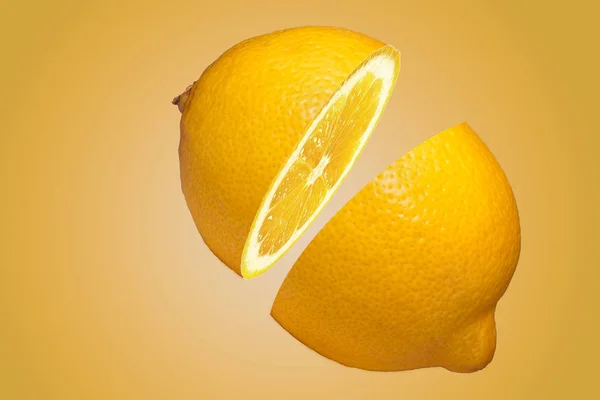 lemon is cut on two parts by a close up on a yellow background