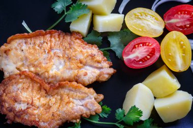 Patates ve siyah figürlü tabakta domates soslu domuz eti biftek