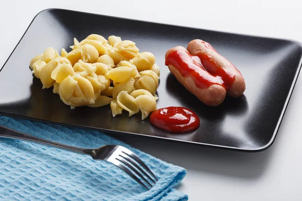 sosis makarna ve figürlü tabak yan görünüm üzerinde baharatlı sos ile