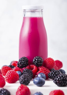 Taze yaz meyve güler yüzlü ahşap arka plan üzerinde cam şişe. Strwberries ve raspberies yaban mersini ve böğürtlen ile.