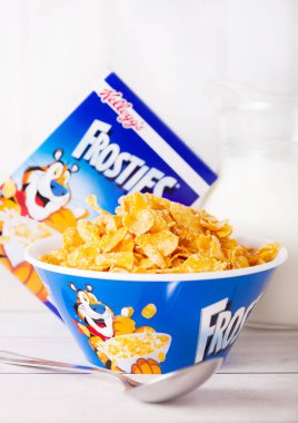 Londra, İngiltere - 01 Haziran 2018: Kutu Kellogg's Frosties kahvaltı gevreği süt ve plaka Beyaz ahşap zemin üzerinde.