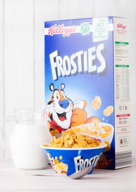 Londra, İngiltere - 01 Haziran 2018: Kutu Kellogg's Frosties kahvaltı gevreği süt ve plaka Beyaz ahşap zemin üzerinde.
