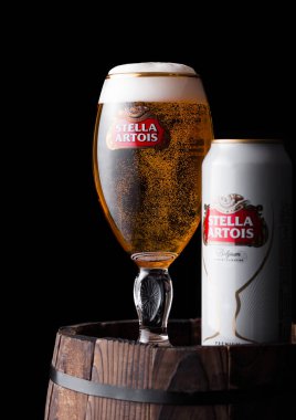 Londra, İngiltere - 06 Haziran 2018: Soğuk cam ve alüminyum kutu Stella Artois bira siyah arka plan üzerine eski ahşap varil üzerinde.