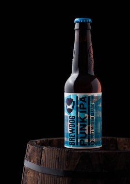Londra, İngiltere - 06 Haziran 2018: Punk IPA şişe bira, siyah arka plan üzerine eski ahşap varil üzerinde Brewdog brewery.