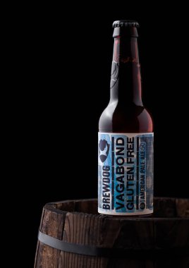 Londra, İngiltere - 06 Haziran 2018: Vagabond şişe Gluten ücretsiz Amerikan soluk ale bira, siyah arka plan üzerine eski ahşap varil üzerinde Brewdog brewery.