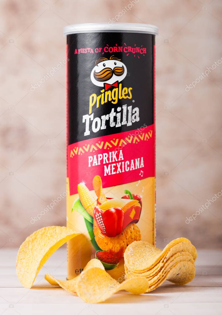 LONDON, UK - JUNE 30, 2018: Pringles potato tortilla chips with paprika on wooden backgrund. Potato and wheat-based stackable snack.