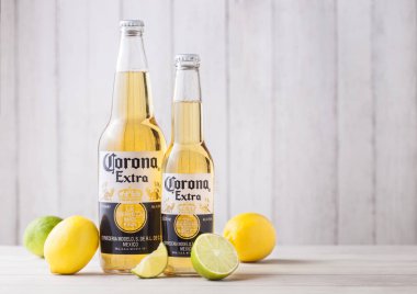 Londra, İngiltere - 27 Nisan 2018: Şişeler, Corona ilave bira taze limon ve limes ahşap zemin üzerine. Corona, Grupo Modelo tarafından üretilen.