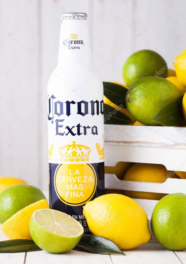 LONDON, UK - APRIL 27, 2018: Steel Bottle of Corona Extra Beer on wooden background with fresh lemons and limes . Corona, produced by Grupo Modelo.