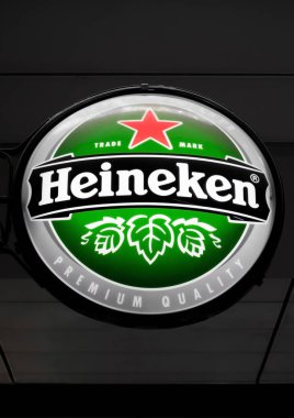 Amsterdam, Hollanda - 18 Temmuz 2018: Yuvarlak billboard Heineken Bira bira pub yanındaki koyu arka plan üzerinde asılı.
