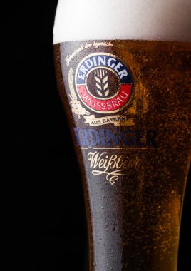 Londra, İngiltere - 28 Temmuz 2018: Orijinal bardak Erdinger bira üstüne siyah ahşap varil. Erdinger dünyanın en büyük buğday bira bira fabrikası ürünüdür.