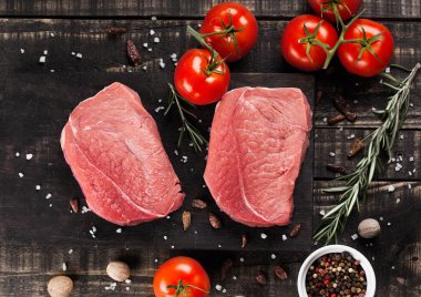 Taze çiğ Dana biftek et ahşap mutfak kurulu domates ve biber ile