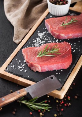 Taze çiğ Dana biftek et taş mutfak kurulu balta ve biber ile