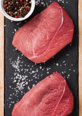 Taze çiğ Dana biftek etli biber siyah arka plan üzerine taş mutfak gemide