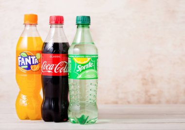 Londra, İngiltere - 03 Ağustos 2018: Ahşap üzerine Coca-Cola ve Fanta ve Sprite meşrubat plastik şişe. Dünyanın en popüler içecek.