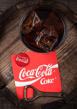 Londra, İngiltere - 10 Ağustos 2018: Coaster özgün Coca Cola meşrubat şişe üst ve açacağı ve ahşap varil üzerine özgün cam.