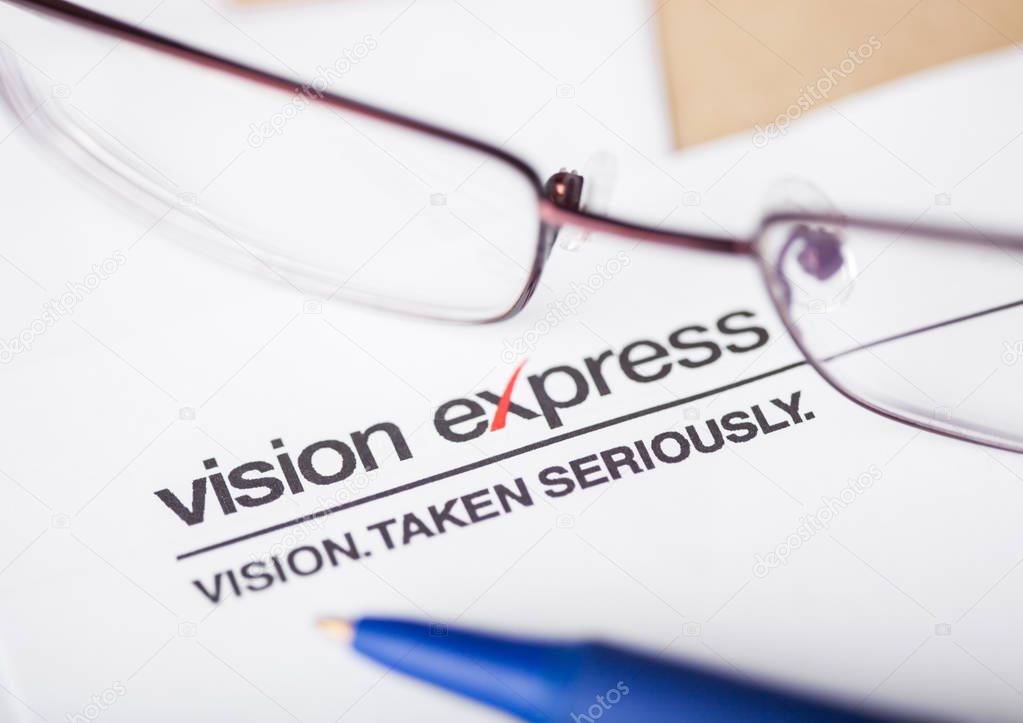 LONDON, UK - AUGUST 18, 2018: Vision Express Logo on papre with glasses and pen.