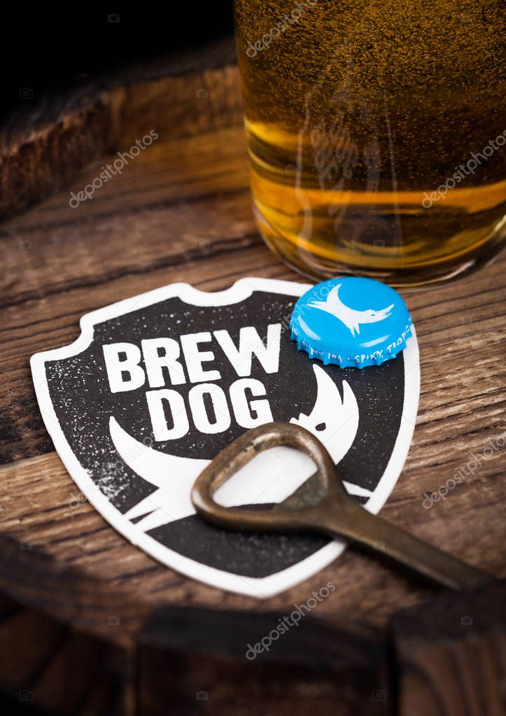 LONDON, UK - AUGUST 10, 2018: Brewdog beer coaster with bottle top and opener and glass of beer on top of wood barrel.