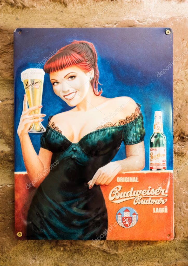 LONDON, UK - AUGUST 31, 2018: Budweiser beer retro vintage steel display plate on brick wall in bar.