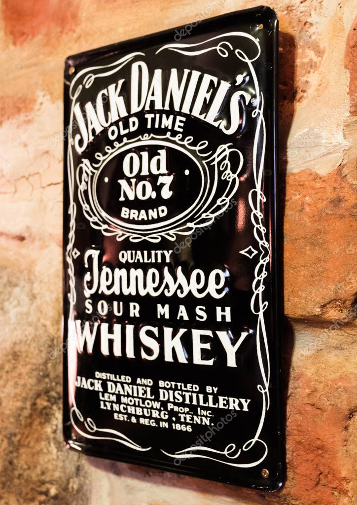 LONDON, UK - AUGUST 31, 2018: Jack Daniels retro vintage steel display plate on brick wall in pub.