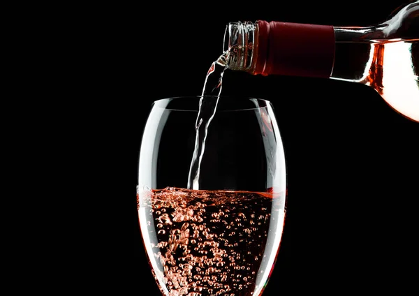 Versare Vino Rosa Rosa Bottiglia Bicchiere Isolato Sfondo Nero — Foto Stock