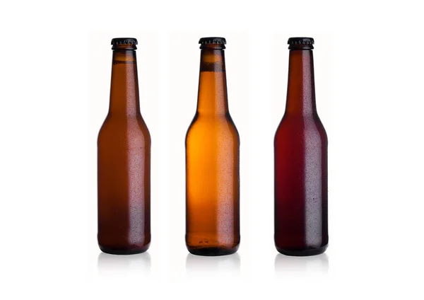 Kahverengi cam bira şişeleri yansıması ile beyaz arka planda siyah kapaklı