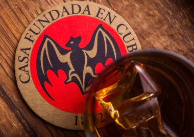 Londra, İngiltere - 04 Eylül 2018: Cam Bacardi Superior ve siyah rum orijinal ahşap tahta altlığı ile.