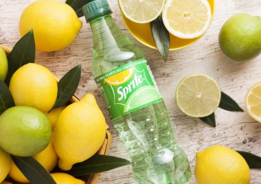 Londra, İngiltere - 03 Eylül 2018: Limon ve limes ahşap zemin üzerine Sprite şişe içki. Sprite limon benzeri aromalı içecek Coca Cola Company tarafından üretilen olduğunu.