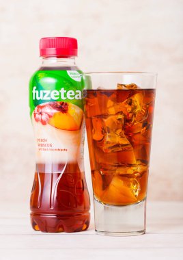 Londra, İngiltere - 03 Eylül 2018: Plastik şişe ve kadeh buz ile Fuzetea buzlu çay ile ahşap üzerine şeftali lezzeti.