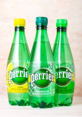 Londra, İngiltere - 03 Eylül 2018: Perrier şişe maden suyu ahşap arka plan üzerinde. Perrier doğal şişe maden suyu dünya çapında satılan Fransız bir markasıdır..