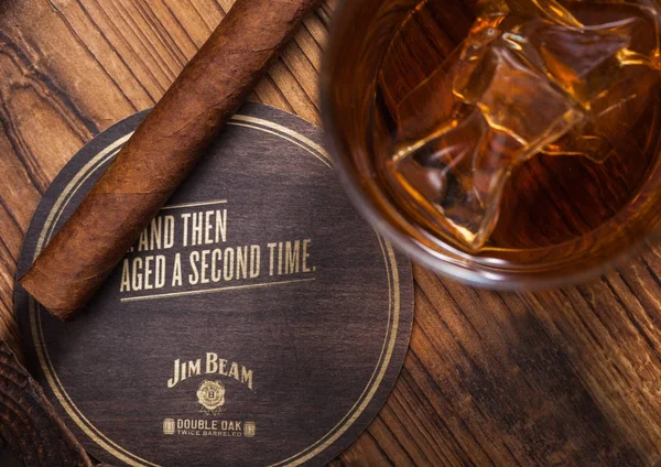 Londra, İngiltere - 04 Eylül 2018: Cam Jim Beam burbon viski ile orijinal coaster ve puro ahşap tahta üzerinde.