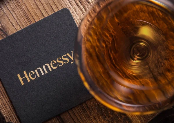 Londra, İngiltere - 04 Eylül 2018: Cam, Hennessy konyak ile ahşap üzerine özgün bardak altlığı.