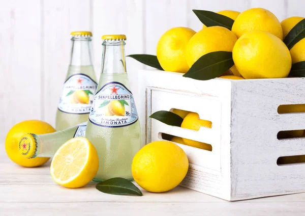 Londra, İngiltere - 03 Eylül 2018: Cam San Pellegrino köpüklü, limon şişe soda İçecek beyaz kutu içinde taze limon ile ahşap arka plan üzerinde.