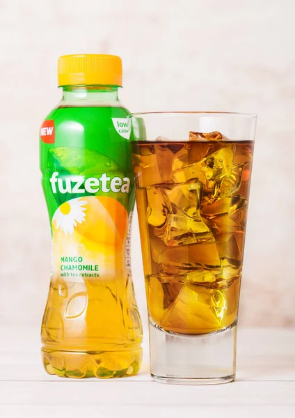 Londra, İngiltere - 03 Eylül 2018: Plastik şişe ve kadeh buz ile Fuzetea buzlu çay ile mango papatya lezzet ahşap üzerine.