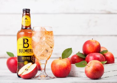 Londra, İngiltere - 13 Eylül 2018: Şişe Bulmers orijinal elma ve buz küpleri ile ahşap arka plan üzerinde taze elma bardak.