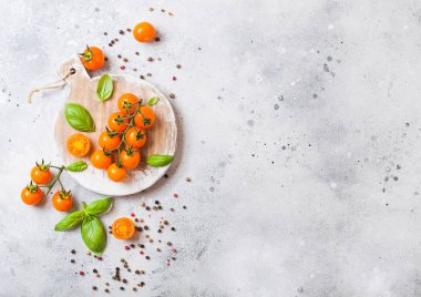 Organik portakal Rapture domates fesleğen ve taş zemin üzerine kıyma kurulu üzerinde biber ile asma üzerinde.