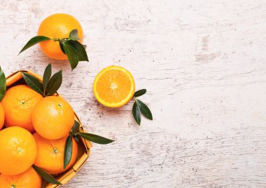 Hafif ahşap zemin üzerine taze ham organik portakal bambu kutusu. Üstten görünüm.