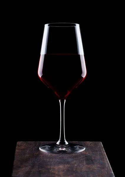 黒い背景に木の板に赤ワインのガラス — ストック写真