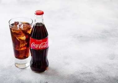 Londra, İngiltere - 28 Eylül 2018: Cam ve Coca Cola soda içki buz küpleri ve taş mutfak arka plan üzerinde kabarcıklar ile şişe.