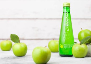Londra, İngiltere - 13 Eylül 2018: Appletiser şişe elma suyu hafifçe köpüklü içecek ahşap arka plan üzerinde taze elma ile.