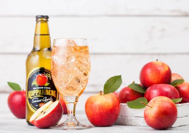 Londra, İngiltere - 13 Eylül 2018: Şişe ve cam Kopparberg tatlı elma elma şarabı ile ahşap arka plan üzerinde taze elma.