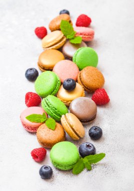 Tatlı pasta macaron veya ahududu ve taş mutfak arka plan üzerinde yaban mersini ile acıbadem kurabiyesi. Üstten görünüm. 