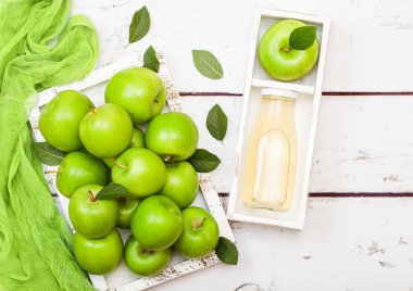 Taze organik elma suyu kutusunda ahşap zemin üzerine yeşil elma ile cam şişe. 