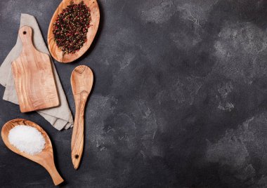 Tablo arka plan üzerinde kurulu ve kase doğrama ile zeytin ahşap mutfak eşyaları taş. Üstten görünüm.