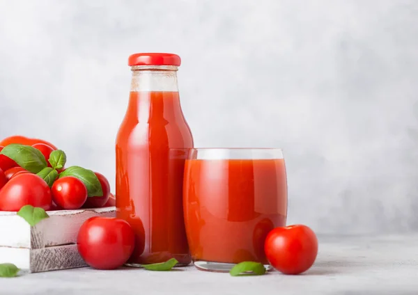瓶和玻璃新鲜的有机番茄汁与新鲜的原始西红柿在盒子上的厨房背景 — 图库照片