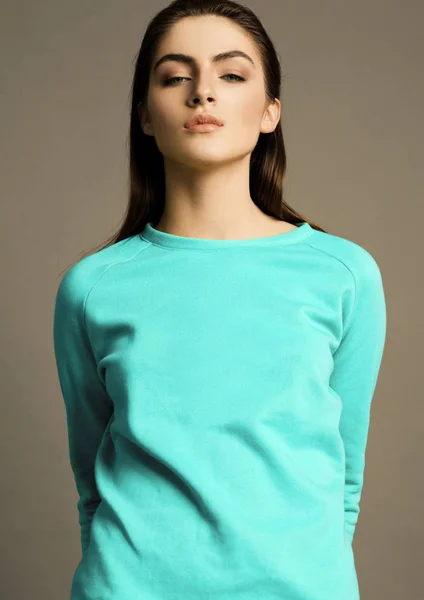 在灰色背景明亮的绿松石毛衣美丽的时尚模型 — 图库照片