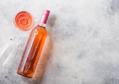 Şişe ve bardak taş mutfak masa arka plan üzerinde pembe gül şarap. Üstten görünüm. 