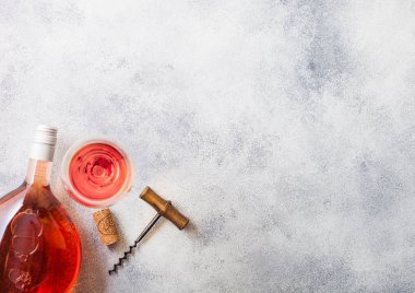 Şişe ve bardak pembe gül şarap cork ve tirbuşon açacağı taş mutfak masa arka plan üzerinde. Üstten görünüm.