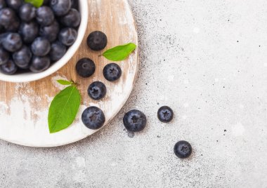 Mutfak arka plan üzerinde beyaz Çin kase yaprak taze ham organik yaban mersini. 