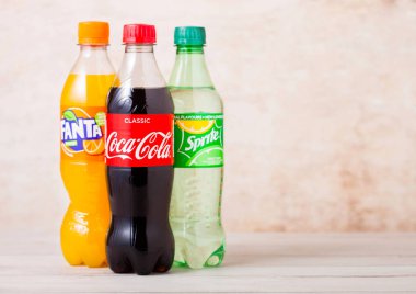 Londra, İngiltere - 03 Ağustos 2018: Ahşap üzerine Coca-Cola ve Fanta ve Sprite meşrubat plastik şişe. Dünyanın en popüler içecek.
