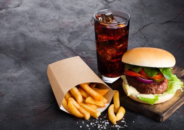 Taze et burger sosu ve sebze ve patates cipsi kişiler üzerine taş mutfak arka plan ile cola meşrubat bardak.